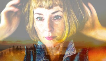 Photo of Jenn Grant. She has short blonde hair and bangs. She is staring just past the camera. The photo is double exposed and behind her we see a fading sunset.
