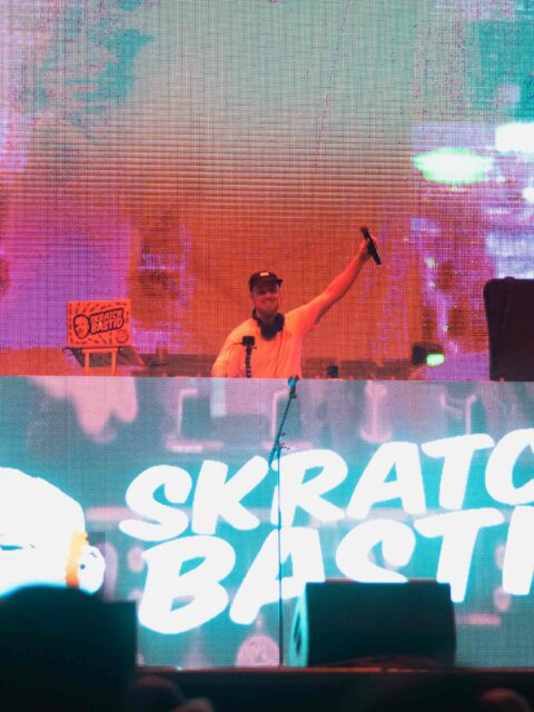 Photo of Skratch Bastid at his DJ turn tables on stage