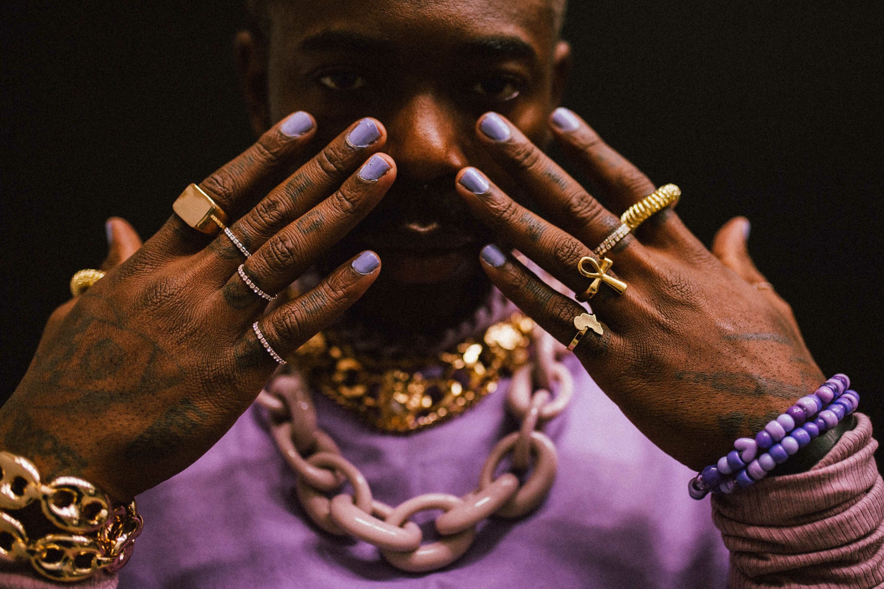 Portrait of Mauvey in a purple sweater and wearing purple nailpolish